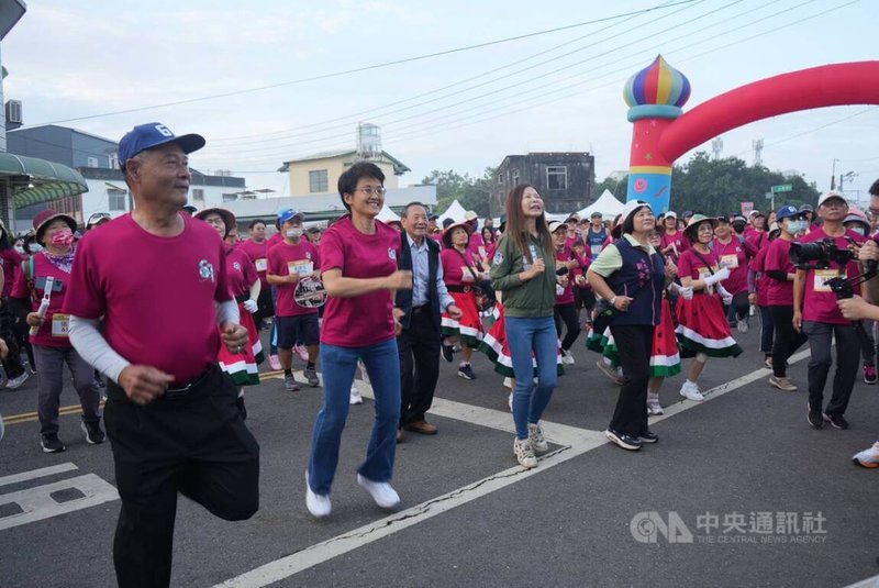 六堆健行路跑活動1日在屏東縣佳冬鄉登場，客委會主委古秀妃（前左2）、佳冬鄉長賴文一（前左1）及多名在地民代，一早在佳冬鄉公所前率跑者跳熱身操。中央社記者黃郁菁攝　115年3月1日