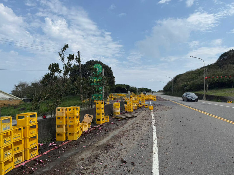 林姓男子2日上午駕駛載運瓶裝米酒的大貨車行經新北市瑞芳區台2線91.4公里處時，因酒箱未確實捆綁導致米酒掉落路面，現場一度飄散陣陣酒香。（讀者提供）中央社記者王朝鈺傳真　115年3月2日