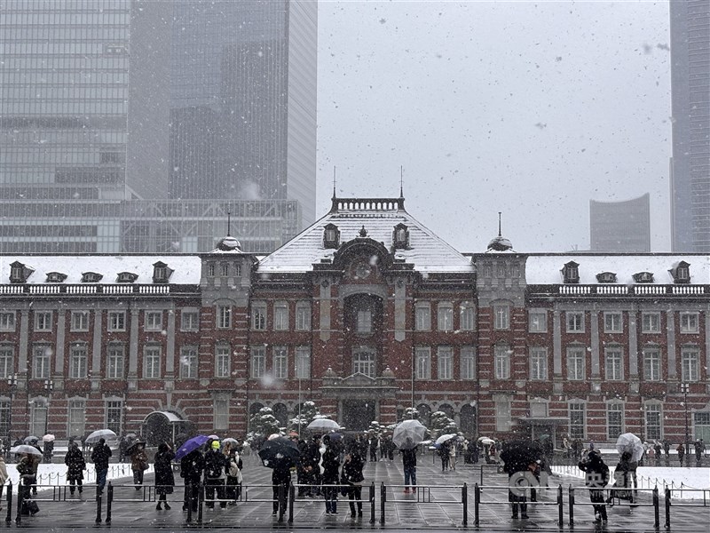 圖為2月8日不少民眾在東京車站前捕捉雪景。（中央社檔案照片）