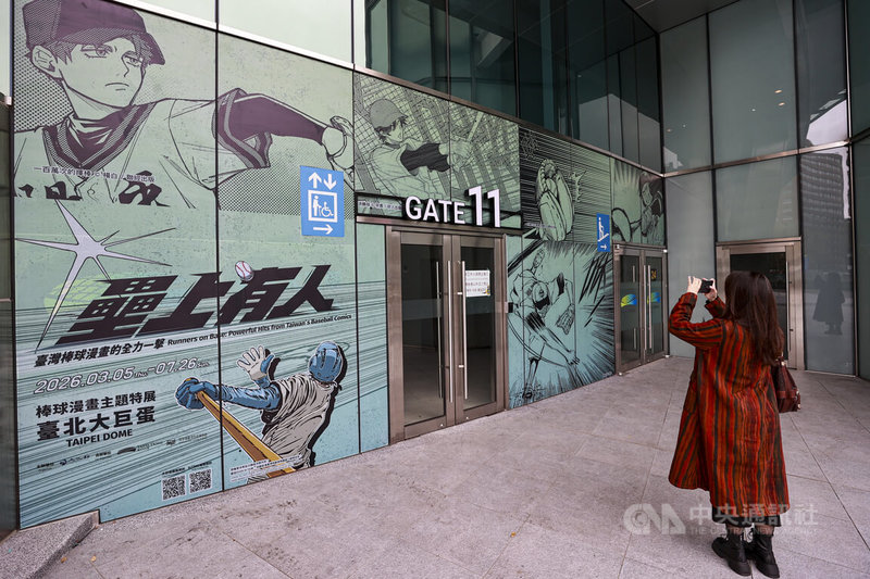 台北大巨蛋外牆設置「壘上有人：台灣棒球漫畫的全力一擊」特展看板，集結多名台灣漫畫家作品，為世界棒球經典賽暖身。圖為3日有民眾外牆看板前駐足拍照。中央社記者鄭清元攝　115年3月3日