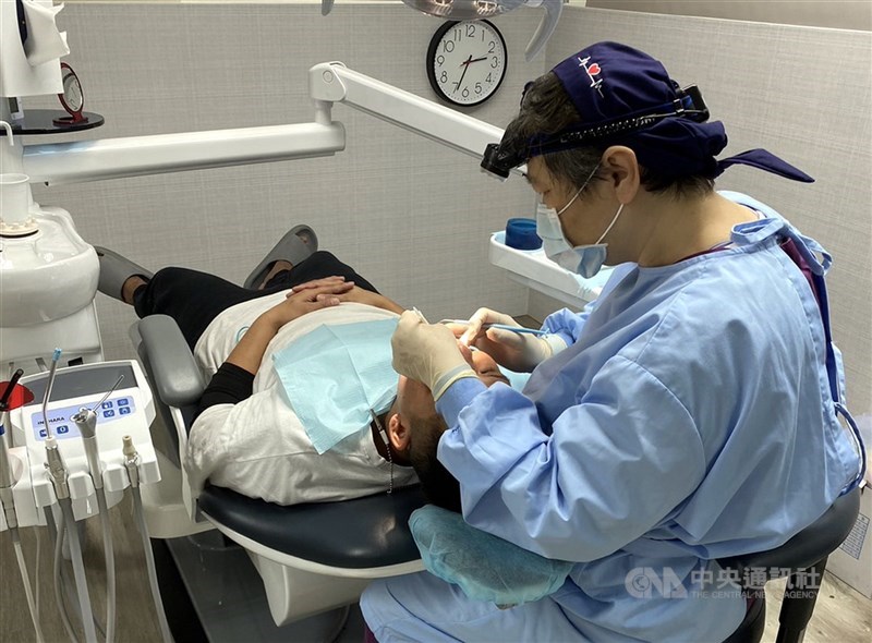 圖為牙醫師為民眾評估裝置假牙。（中央社檔案照片）