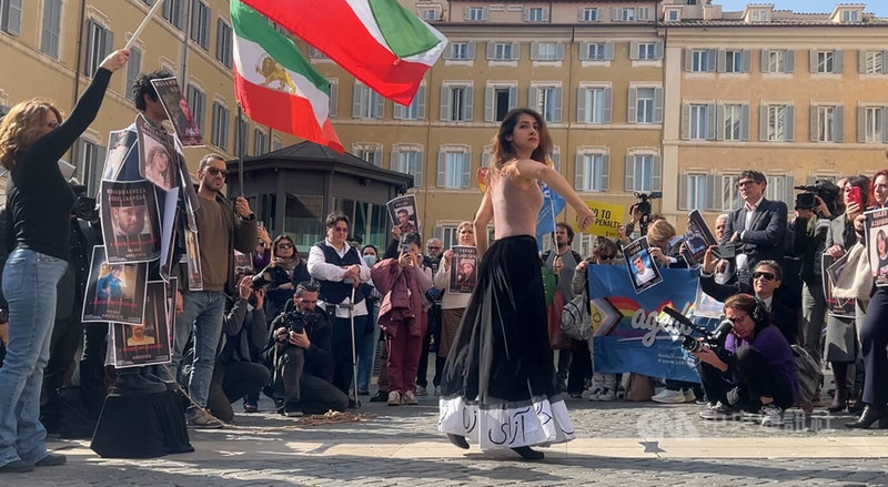 義大利國會前的廣場3日舉行一場快閃活動，呼籲各界施壓伊朗釋放成千上萬的政治犯。圖為快閃行動中的表演，伊朗青年身上貼滿政治犯照片，伊朗女舞者以淒美又具有力量的舞姿表達訴求。中央社記者黃雅詩羅馬攝 115年3月4日