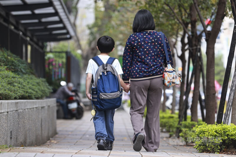 台北市勞動局表示，「育兒減少工時」試辦計畫開放申請進入第3天，已有近30家事業單位提出申請。圖為家長牽著孩子步行。（中央社檔案照片）