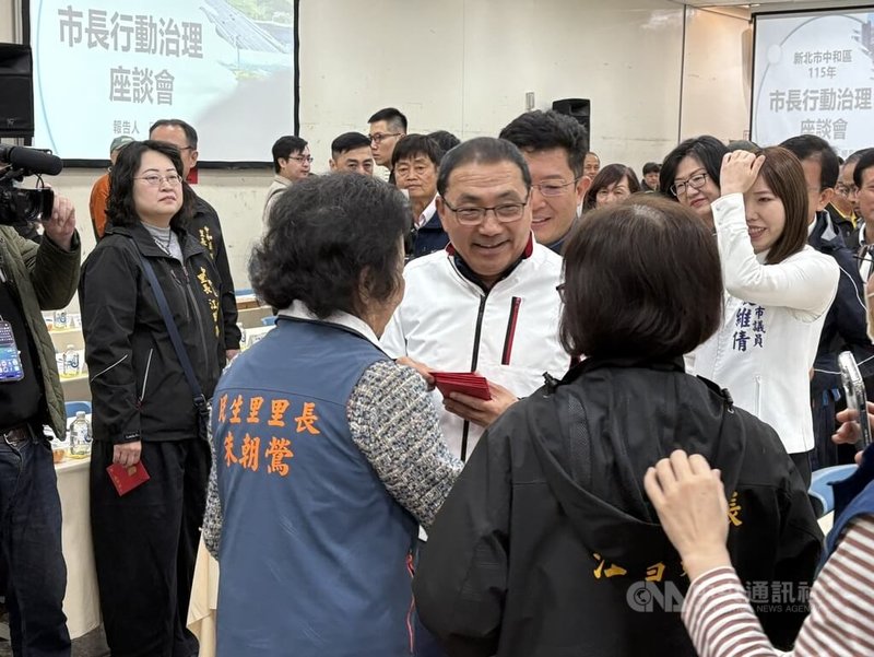 新北市長侯友宜（中）5日率新北市政府團隊到新北中和區出席行動治理座談會，會前向里長發送福袋。中央社記者曹亞沿攝 115年3月5日