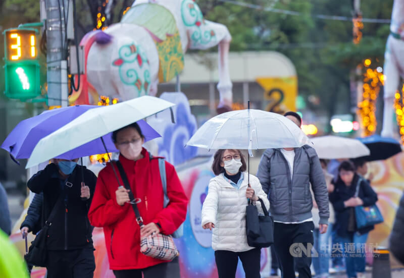 圖為台北市西門商圈傍晚飄著細雨，民眾披上外套、撐傘外出活動。（中央社檔案照片）