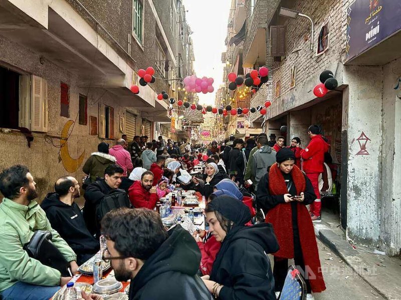 開羅市郊瑪塔瑞亞地區內的貧民區5日舉行年度「瑪塔瑞亞大開齋宴」，近700張桌子相連，提供免費開齋飯，街道兩旁掛滿燈籠、彩旗與氣球。中央社記者施婉清開羅攝　115年3月6日