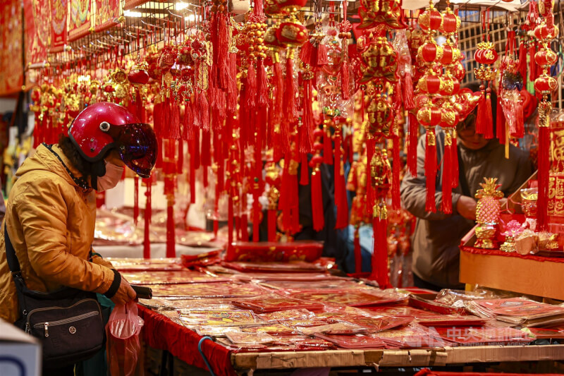 圖為民眾在農曆春節前赴市場購買年節飾品。（中央社檔案照片）