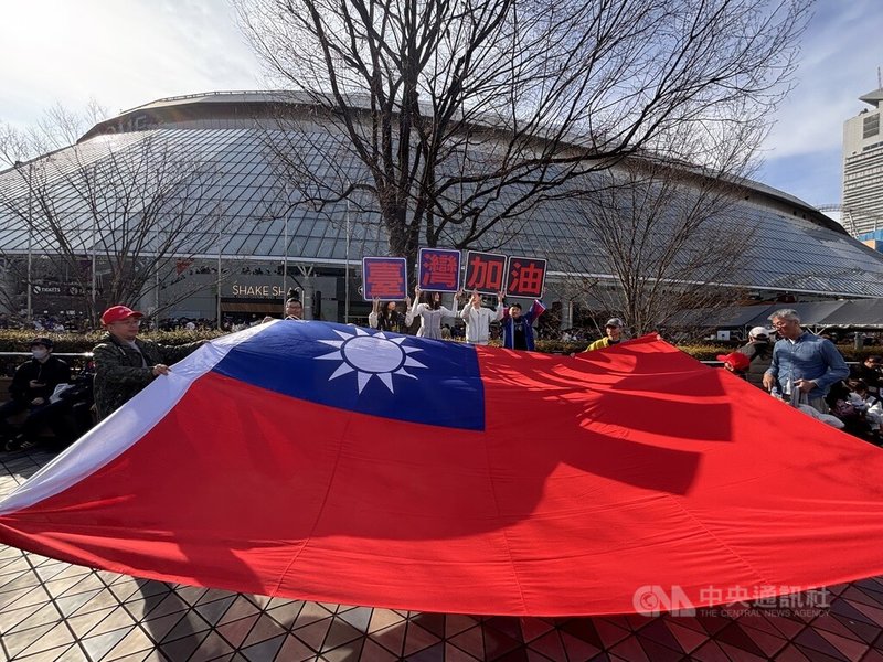 世界棒球經典賽（WBC）台灣隊7日「晚接午」迎戰捷克隊，最終以14比0在7局提前結束比賽，成功「扣倒」對手。興奮的台灣球迷賽後聚集在東京巨蛋周邊張開巨幅國旗，高喊「台灣加油」。中央社記者戴雅真東京攝　115年3月7日