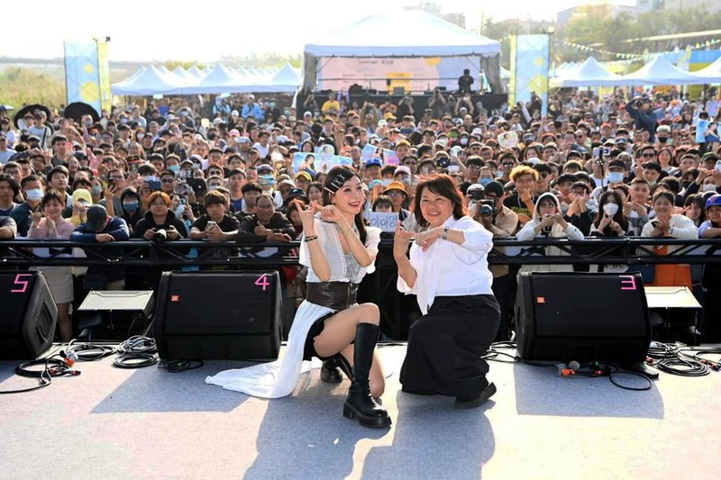 嘉義市政府7日在八掌溪河堤舉辦「潮風鈴．黃花瘋音樂市集」，韓籍啦啦隊成員李雅英（前左）現身，和嘉義市長黃敏惠（前右）一同與現場民眾合影。（嘉義市政府提供）中央社記者蔡智明傳真　115年3月7日