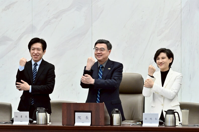 行政院長卓榮泰（中）5日上午在行政院會比出經典賽台灣隊這次上壘的「抓手腕」手勢，聲援賽事。（行政院提供）