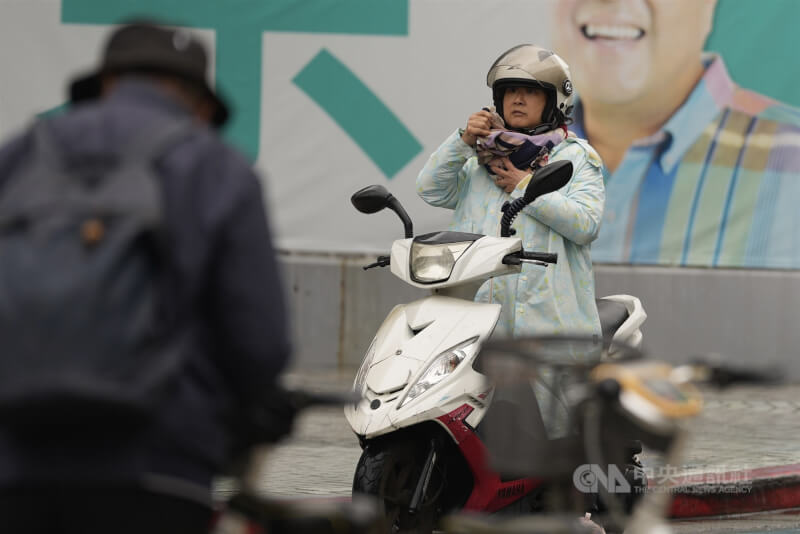 中央氣象署測報7日凌晨本島平地最低溫為苗栗公館鄉攝氏10.8度。圖為北市北投區機車騎士停等時調整圍巾禦寒。（中央社檔案照片）