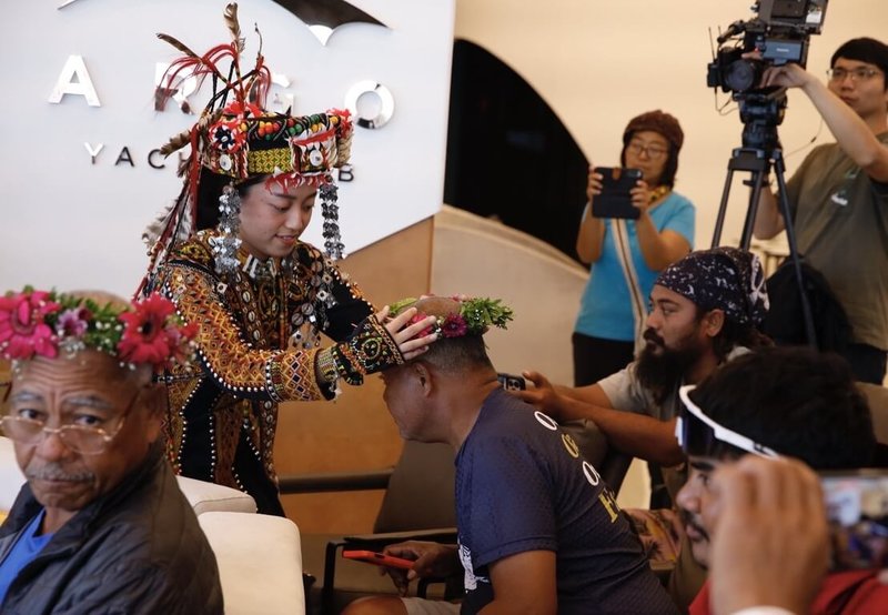 帛琉傳統遠洋航海帆船「無私分享號」航抵台灣，8日由國立中山大學等單位在亞果高雄愛河灣會所舉辦「水路交匯座談」活動，以魯凱族神山部落族人為與會者戴上花圈進行祝禱揭開序幕。（海洋委員會提供）中央社記者張已亷傳真　115年3月8日