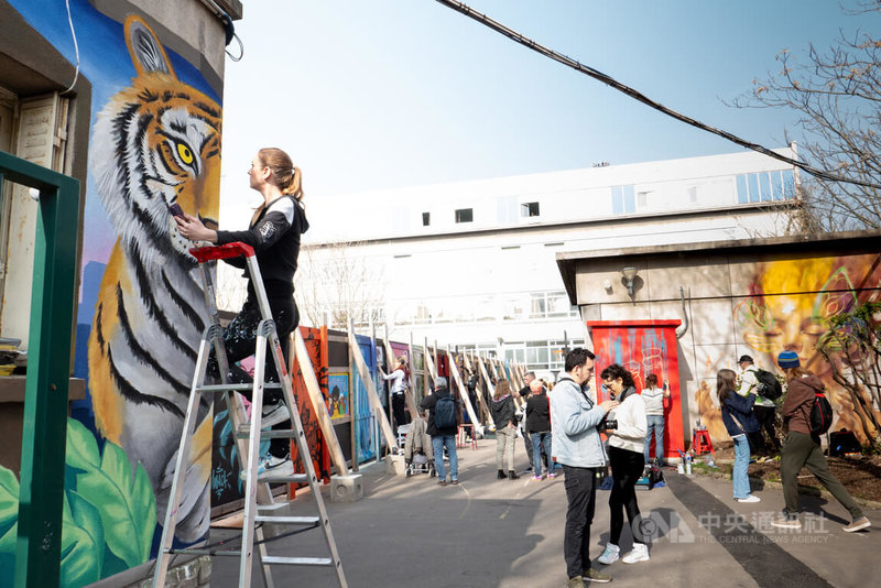 巴黎克里斯蒂諾賈西亞緊急安置中心原有一整排約40公尺長、2.5公尺高的圍牆。為改善嚴肅氛圍，3月8日國際婦女節期間，40多位女性塗鴉藝術家運用色彩與想像力，為中心增添新氣息。中央社記者李若韻巴黎攝　115年3月9日