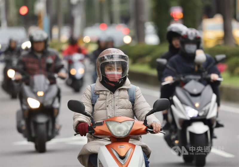台北市街頭機車騎士穿保暖衣物禦寒。（中央社檔案照片）