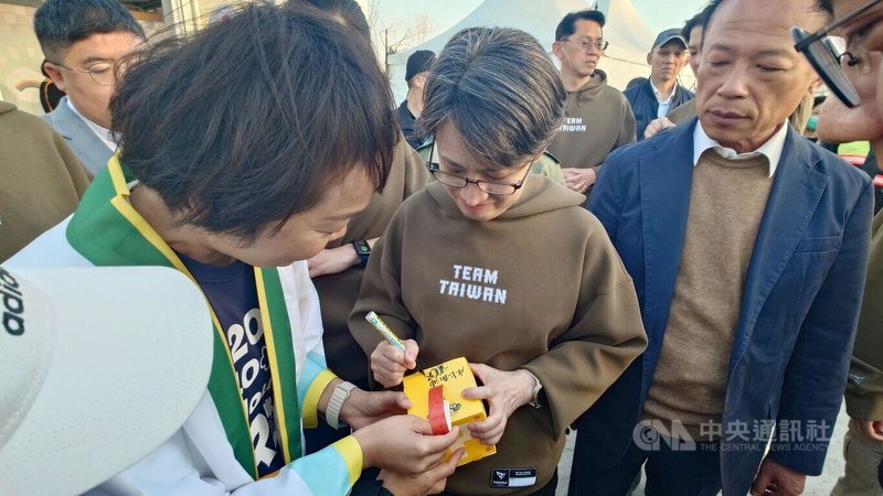 副總統蕭美琴（中）11日傍晚抵達嘉義縣參觀2026台灣燈會，水上鄉長林緗亭（前左）拿著小提燈給蕭副總統簽名，蕭副總統寫上「水上加油」。右為嘉義縣長翁章梁。中央社記者蔡智明攝　115年3月11日