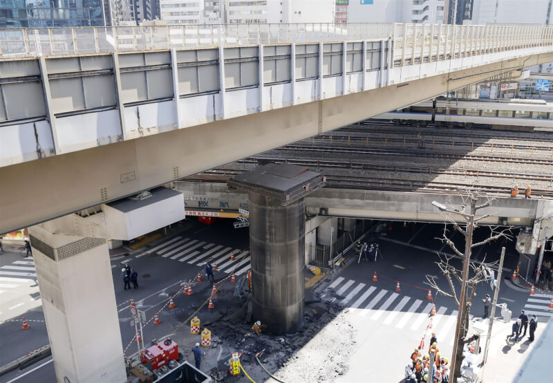 日本大阪市北區茶屋町的鬧區街頭11日地下管線衝破柏油路面，一度逼近上方高架橋。圖為上午11時現場畫面。（共同社）