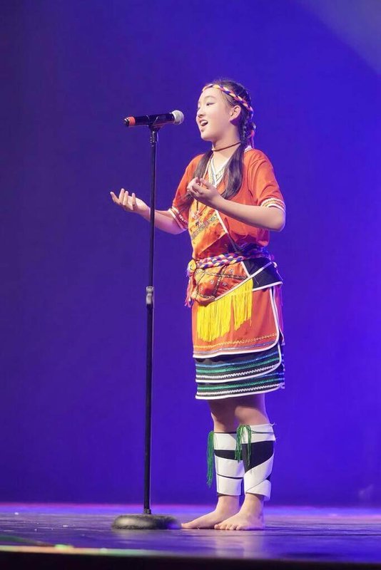 南非台裔少女蔡穎兒身穿台灣原住民族阿美族傳統服飾，在南非表演藝術錦標賽世界音樂項目中演唱「站在高崗上」，展現台灣文化特色。（蔡穎兒父親蔡澤秀提供）中央社記者李依璇傳真　115年3月12日