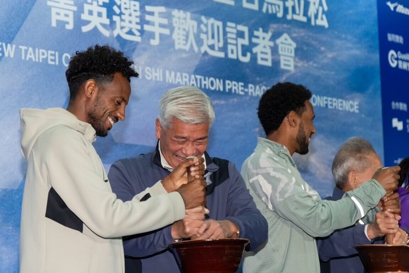 2026新北市萬金石馬拉松國際菁英選手歡迎記者會13日舉行，來自衣索匹亞的選手莫格斯（Ashenafi Moges Weldegiorgis）（左）與厄利垂亞選手海爾米凱爾（Samsom Amare Hailemicael）（左3）現場體驗客家擂茶。（新北市體育局提供）中央社記者黃旭昇傳真　115年3月13日