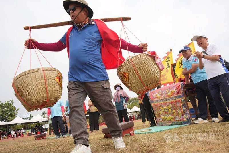 六堆運動會特色趣味競賽「挑擔奉忠勇」參賽者須挑擔通過障礙,在忠勇公神桌前擲出聖筊,才能折返讓下一棒接力,結合運動與客家敬神、保鄉衛土歷史。中央社記者黃郁菁攝 115年3月15日