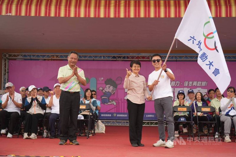 第61屆六堆運動會15日落幕，下屆大會會長高樹鄉長梁正翰（前右），在客委會主委古秀妃（前中）見證下，自本屆大會會長佳冬鄉長賴文一（前左）手中接下大會會旗，相約2027年高樹見。中央社記者黃郁菁攝　115年3月15日