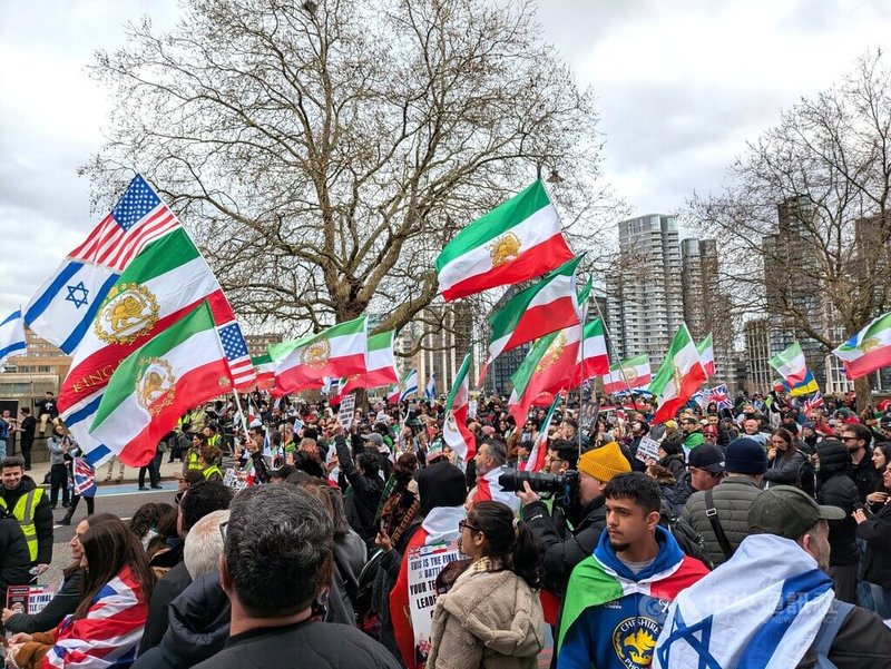 旅英伊朗人、以色列人等數百民眾15日在倫敦市中心泰晤士河北岸集會，支持美國和以色列對伊朗發起的軍事行動。現場可見遭德黑蘭當局嚴禁的伊朗「獅子與太陽」旗，象徵1979年伊斯蘭革命以前的伊朗。中央社記者陳韻聿倫敦攝　115年3月16日