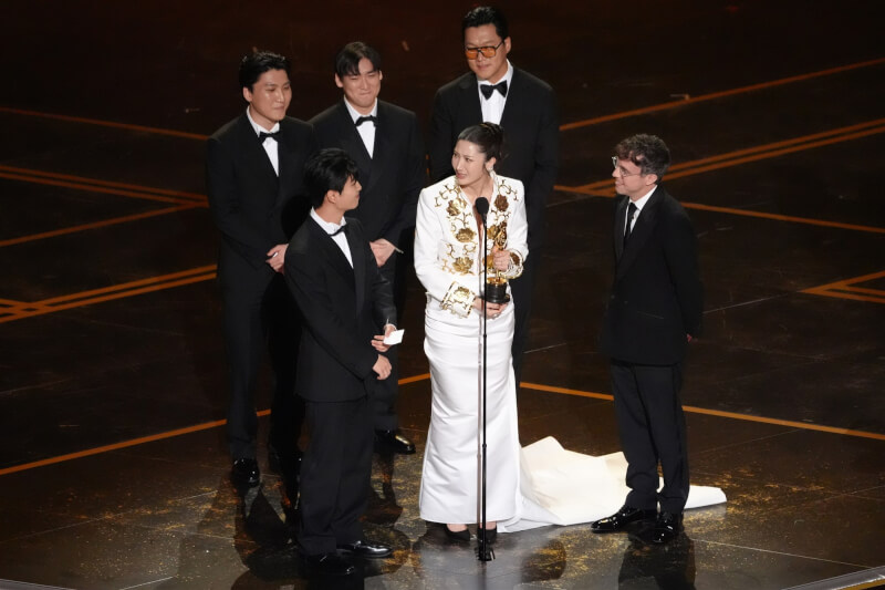 「Kpop獵魔女團」15日在奧斯卡奪下2項大獎，演唱Golden並參與創作的歌手EJAE（前中）上台發表感言。（美聯社）