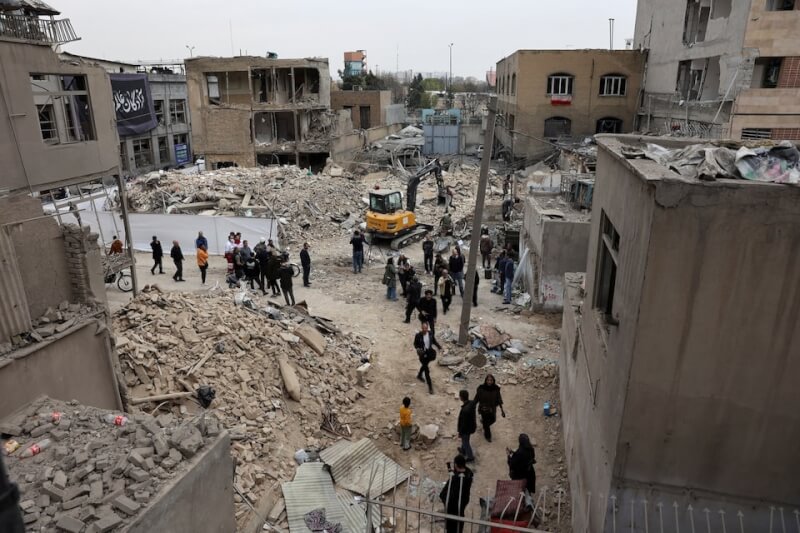 伊朗首都德黑蘭15日遭襲擊後，居民從倒塌的房屋走出。（Majid Asgaripour/WANA (West Asia News Agency) via 路透社）