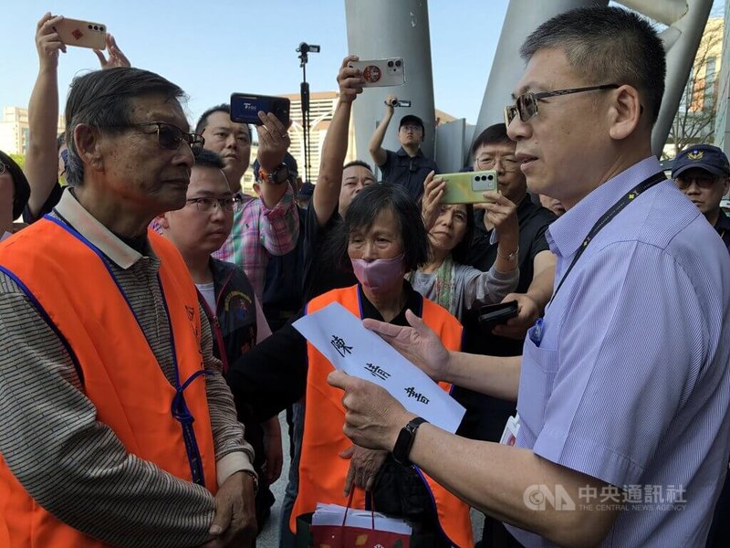 嘉義市文化路夜市自治會18日至市府前抗議並遞交陳情書，指控有合法女攤販日前遭違規攤販毆打，要求市府、警方介入處理，後續由建設處長羅資政（前右）代表收下陳情書。中央社記者黃國芳攝　113年3月18日