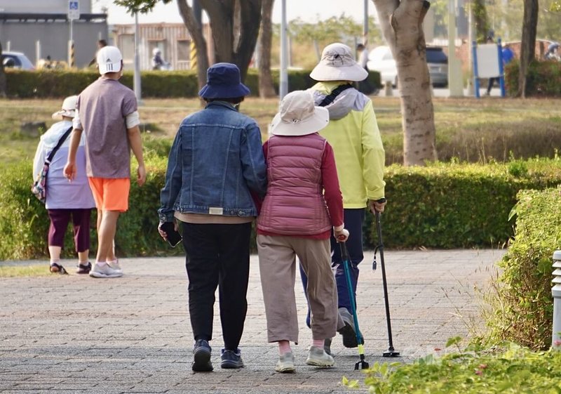 行政院會19日通過「獨居老人關懷服務計畫」，將擴大推動獨居老人服務，預計擴大訪查75歲以上獨居老人、擴大補助7萬名長者安裝緊急救援系統、新增送餐服務，以及積極推動關懷服務等。圖為高雄市鳳山區多名拄著拐杖的長者在公園內健走散步。中央社記者董俊志攝　115年3月19日