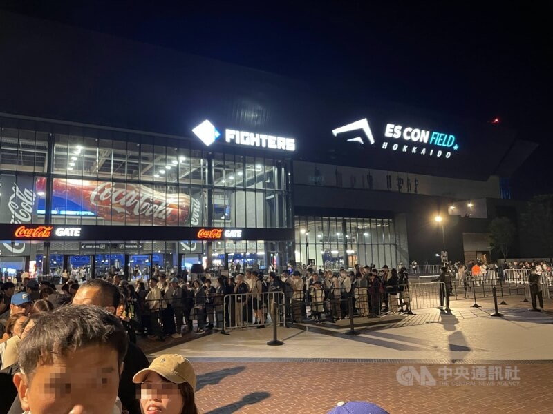 球賽散場時，球迷排隊準備搭乘接駁車。（中央社）