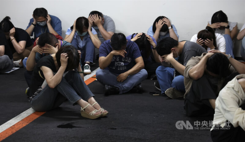 2025年城鎮韌性防空演習7月登場，松山區公所地下室有許多民眾配合避難演練，做出防護姿勢。（中央社檔案照片）