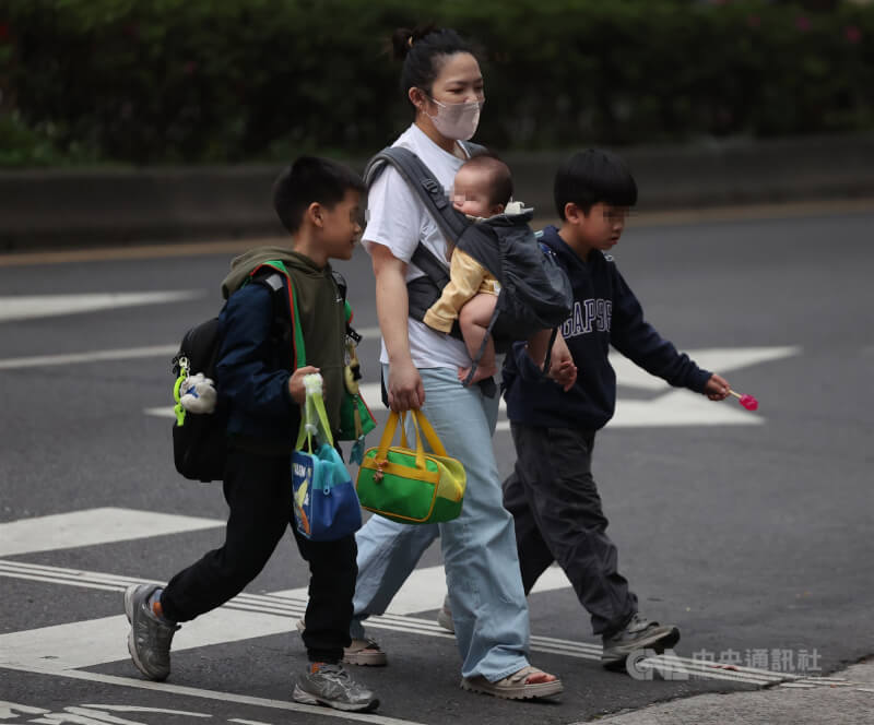 行政院會19日拍板放寬外籍幫傭申請條件，4月13日起，放寬家有未滿12歲孩童即可申請外籍幫傭。圖為放學時段，台北市家長陪著小孩一同回家。（中央社檔案照片）