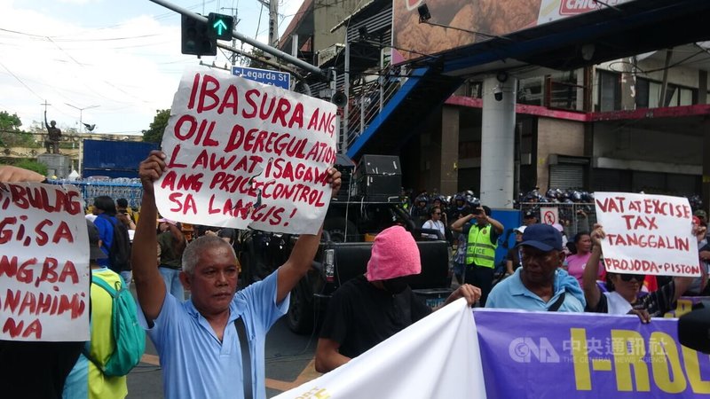 菲律賓油價節節攀升，衝擊司機生計。運輸團體PISTON於20日舉行接連第2天的示威。圖為一名示威者舉牌要求政府廢除「石油產業自由化法」，恢復油價管制。中央社記者林行健馬尼拉攝　115年3月20日