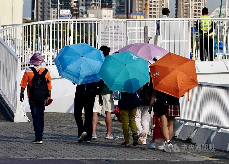 圖為高雄駁二藝術特區周邊民眾撐傘遮陽。（中央社檔案照片）