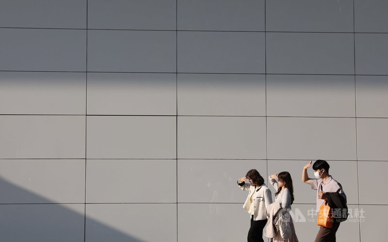 台北信義商圈22日午後天氣晴朗，路上民眾舉手遮擋陽光。中央社記者趙世勳攝　115年3月22日