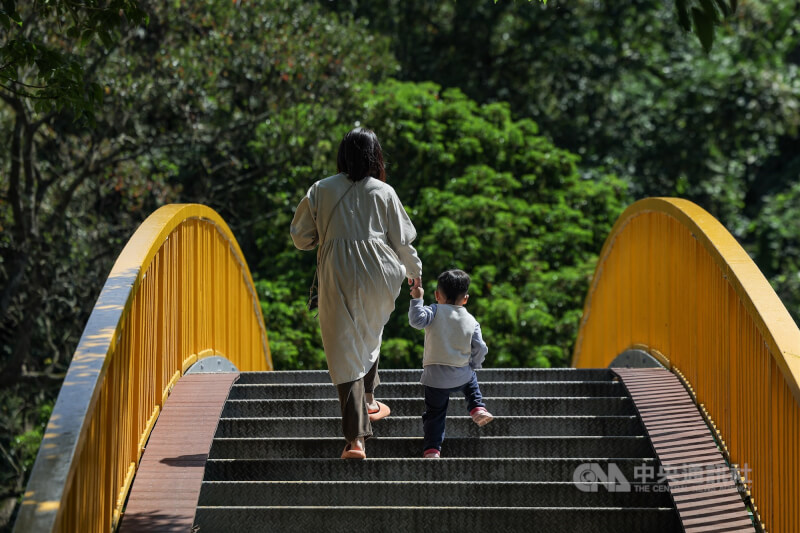 圖為台北市內湖區民眾帶著小孩散步。（中央社檔案照片）