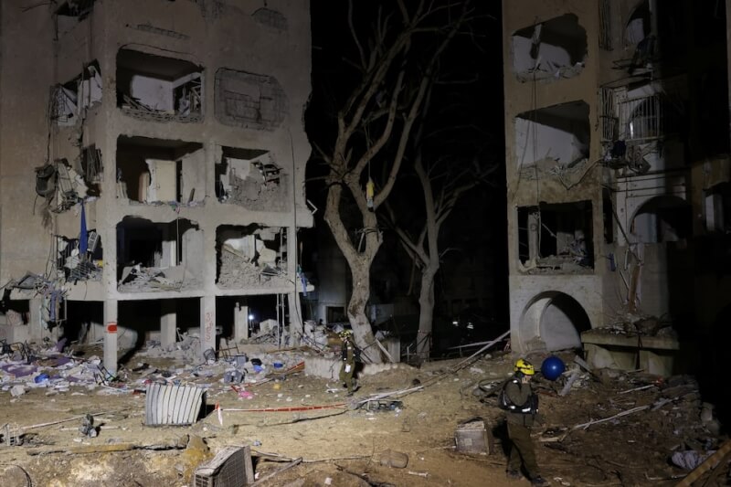 以色列士兵在22日在阿拉德鎮遭伊朗飛彈襲擊後清理現場。（路透社）