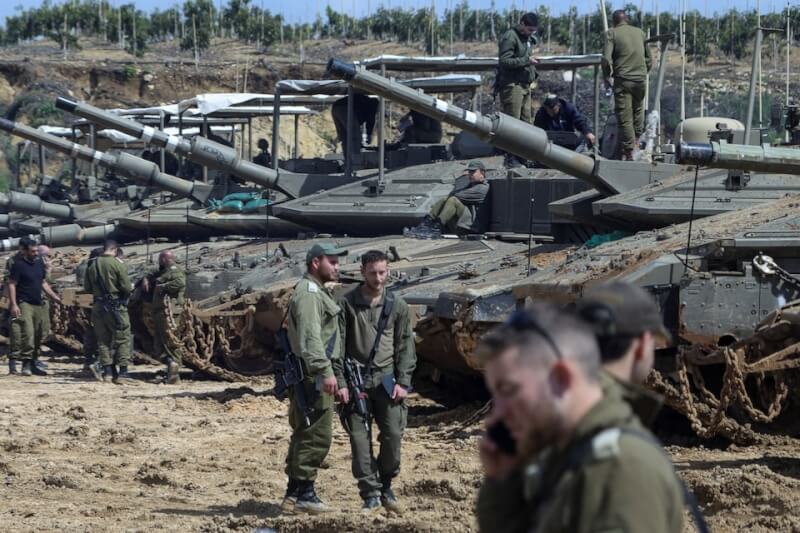 23日以色列士兵站在黎巴嫩邊境附近的坦克車旁。（路透社）