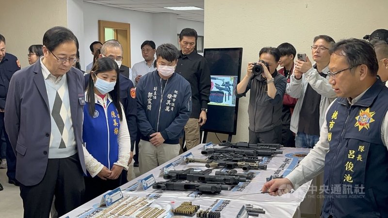 桃園市政府警察局24日舉行偵破幫派軍火庫記者會，桃園市長張善政（左1）聽取警方解說並視察查扣的彈藥槍枝。中央社記者葉臻攝　115年3月24日