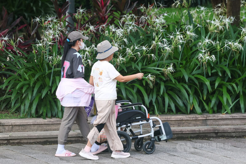 圖為台北市中山區一處公園內移工與雇主一同散步活動。（中央社檔案照片）