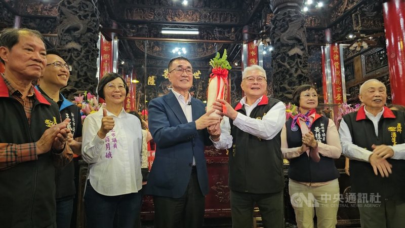 國民黨新北市長參選人李四川（右4）25日到蘆洲湧蓮寺參拜，湧蓮寺主委陳宏昌（右3）致贈象徵好彩頭的「菜頭」，現場也頻傳「凍蒜」聲。中央社記者王鴻國攝　115年3月25日