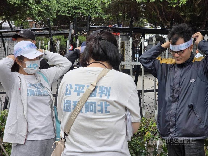 台北地院審理京華城、柯文哲政治獻金案26日下午2時30分一審宣判。前台北市長柯文哲支持者「小草」在北院周邊愛國東路與博愛路口集結，綁上頭帶聲援柯文哲。中央社記者謝君臨攝　115年3月26日