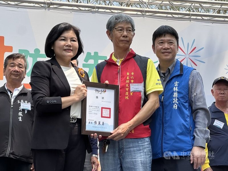 雲林縣斗六市榴中社區以往逢豪雨必淹，縣府和公所編列預算解決淹水問題，居民自主成立防災巡守隊，汛期間的作為獲得縣府讚許，雲林縣長張麗善（前左）26日頒發獎狀給榴中社區，由里長蔡芳聰（前中）代表領取。中央社記者姜宜菁攝　115年3月26日