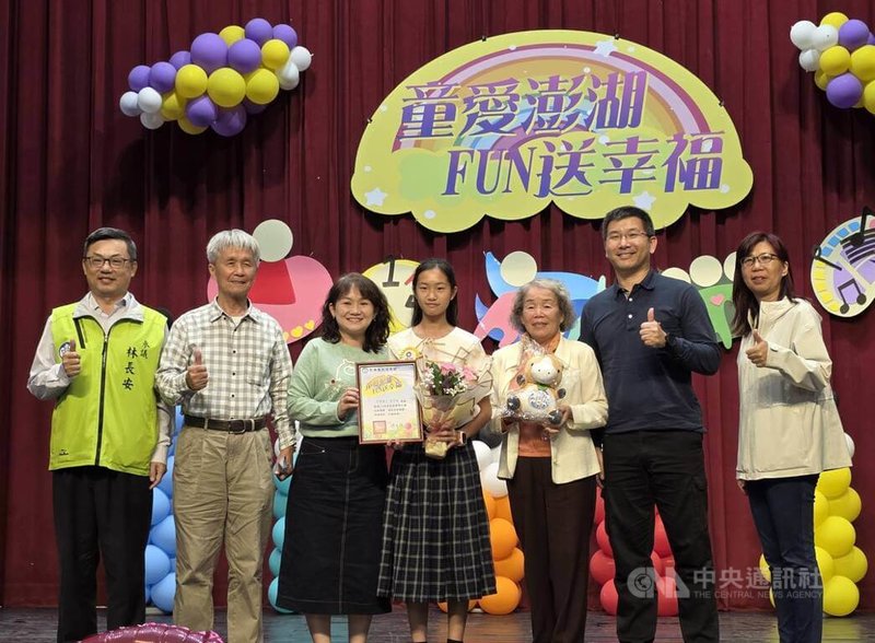 澎湖縣政府27日舉行「童愛澎湖、FUN送幸福」兒童節表揚大會，澎湖縣政府參議林長安（左）代表縣長陳光復對獲得模範兒童表揚的學生表達肯定。中央社  115年3月27日