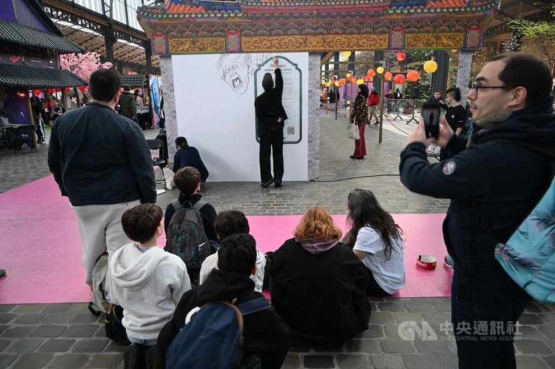 艾莉柚與藥島在布魯塞爾書展會場合作創作漫畫,吸引許多民眾圍觀、拍攝。中央社記者吳柏緯布魯塞爾攝 115年3月27日
