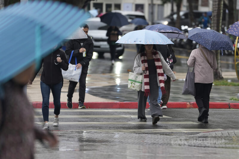 圖為民眾通勤時，撐傘在台北市北投區街頭穿梭。（中央社檔案照片）