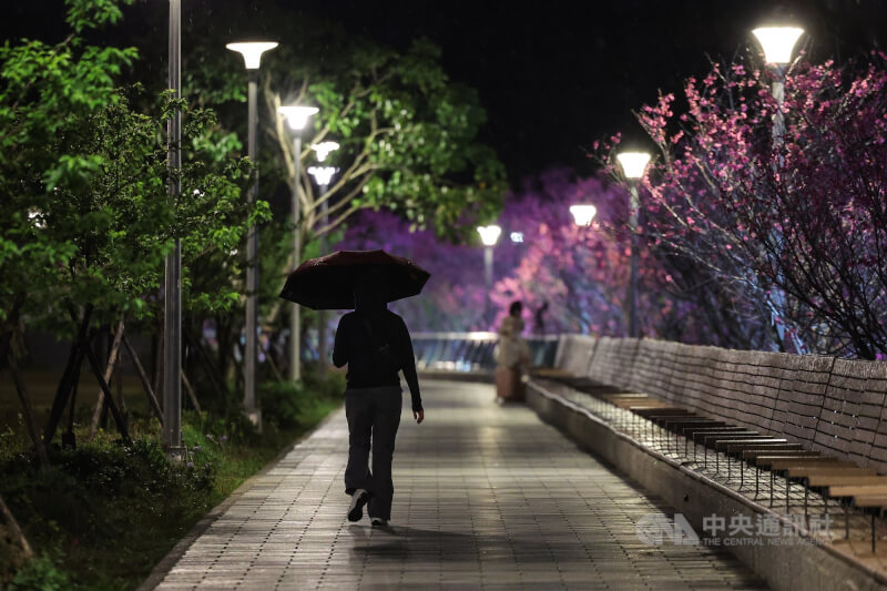 圖為民眾於台北市內湖區樂活公園撐傘散步。（中央社檔案照片）