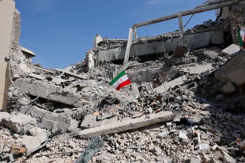 伊朗德黑蘭一座警察局遭到攻擊後，一面伊朗國旗矗立在廢墟中。（路透社）