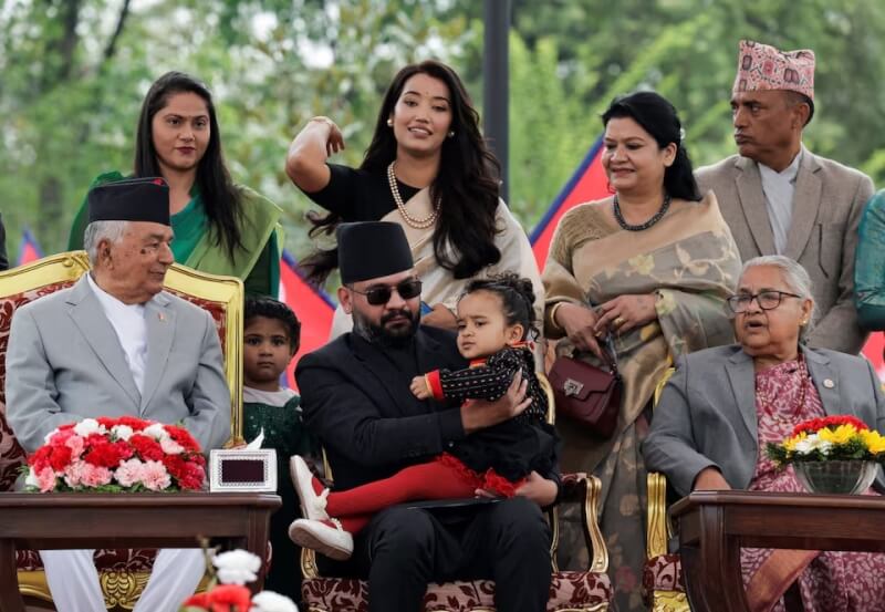 前尼泊爾首都市長夏哈（前中）27日宣誓就任總理，他在就職典禮上抱著女兒亮相。（路透社）