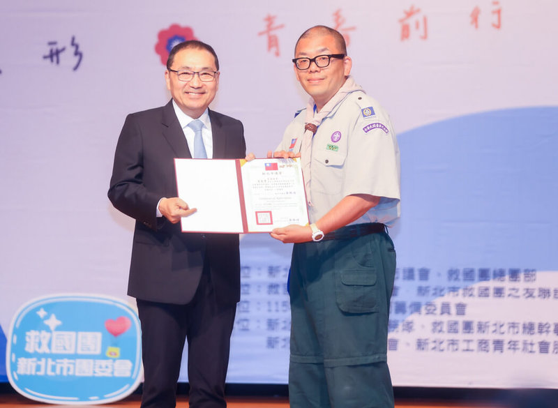 新北市28日表揚132名優秀青年，市長侯友宜（左）頒獎給泰山國中教師、童軍團長賀楚彎（右），肯定其持續推動童軍教育，培養學生服務社會精神。（新北市政府新聞局提供）中央社記者黃旭昇傳真　115年3月28日
